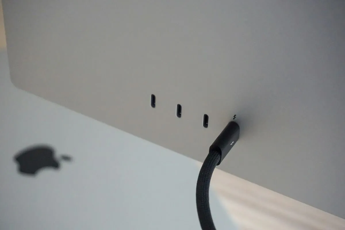 An apple computer is plugged into a charger